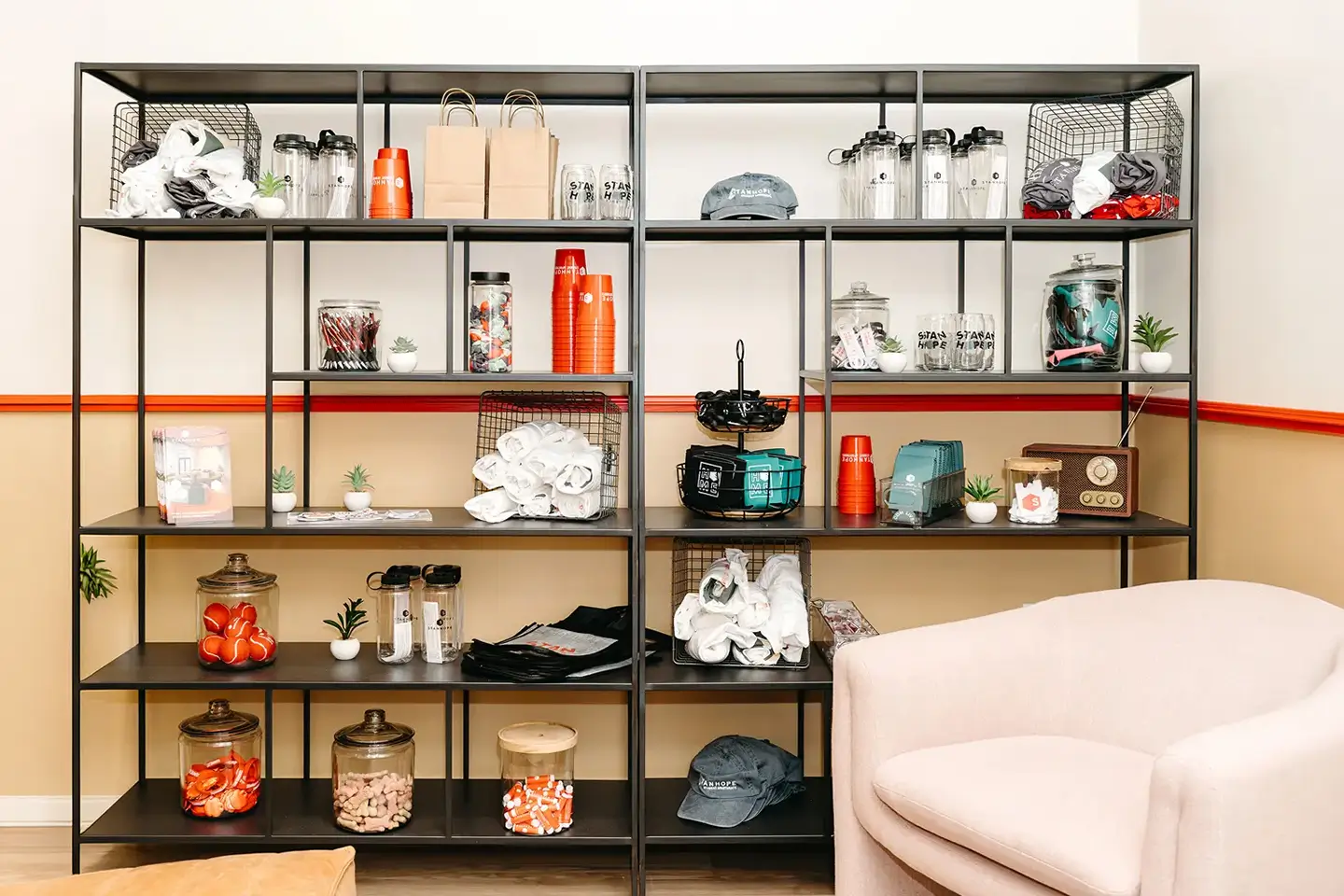 Community items placed decoratively within shelving next to a seating area.